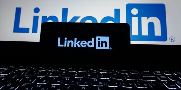 Geschaeftsfrau am Laptop mit LinkedIn Oberflaeche im Buero