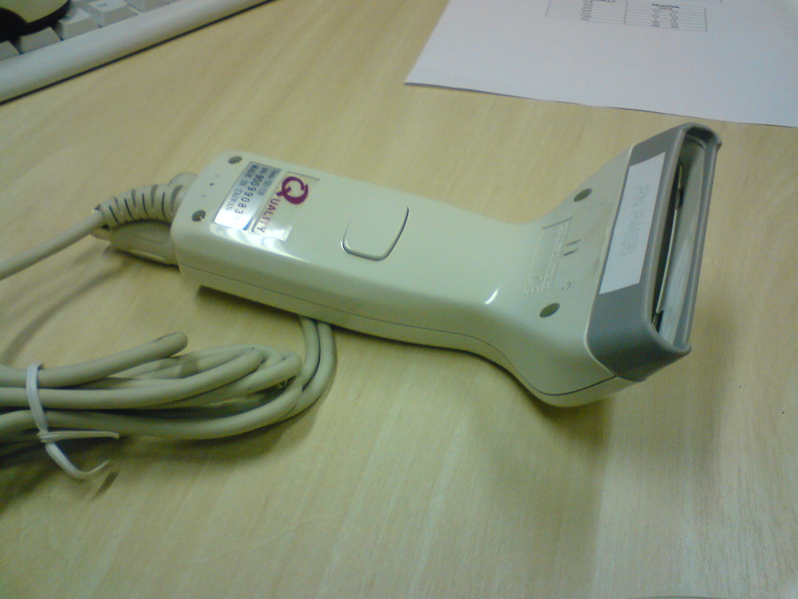 Handscanner erfasst den Strichcode auf einer Produktverpackung, im Hintergrund gestapelte Kartons