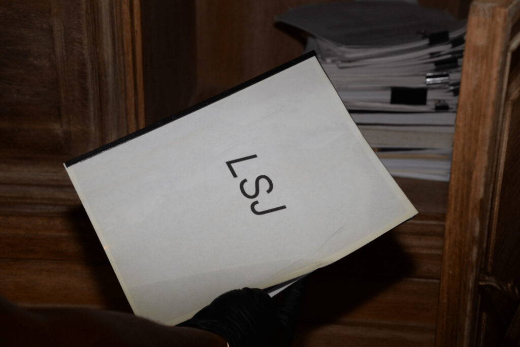 Stapel bedruckter Blätter auf einem Schreibtisch, oben liegt ein Kugelschreiber quer
