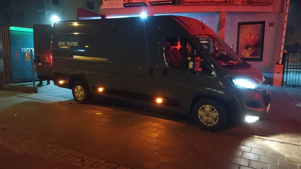Paket steht vor einer Haust&uuml;r auf der Fu&szlig;matte, daneben liegt ein Lieferschein