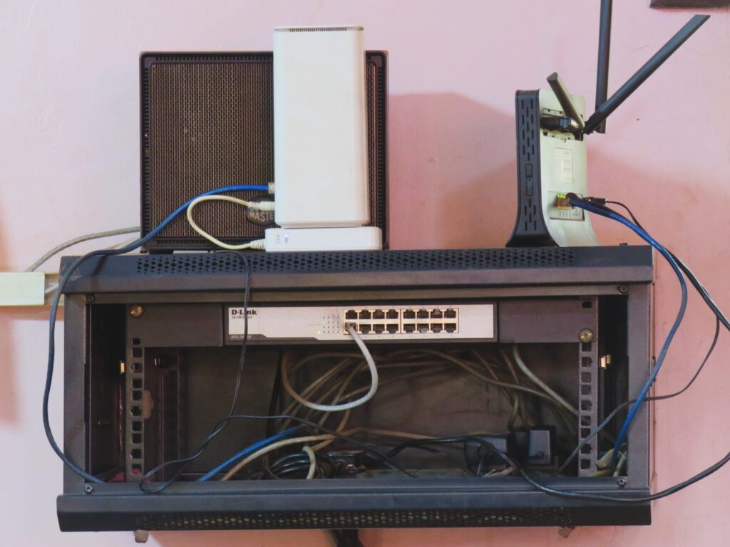 Netzwerkkabel in mehreren Farben stecken geordnet in einem Verteiler an der Wand