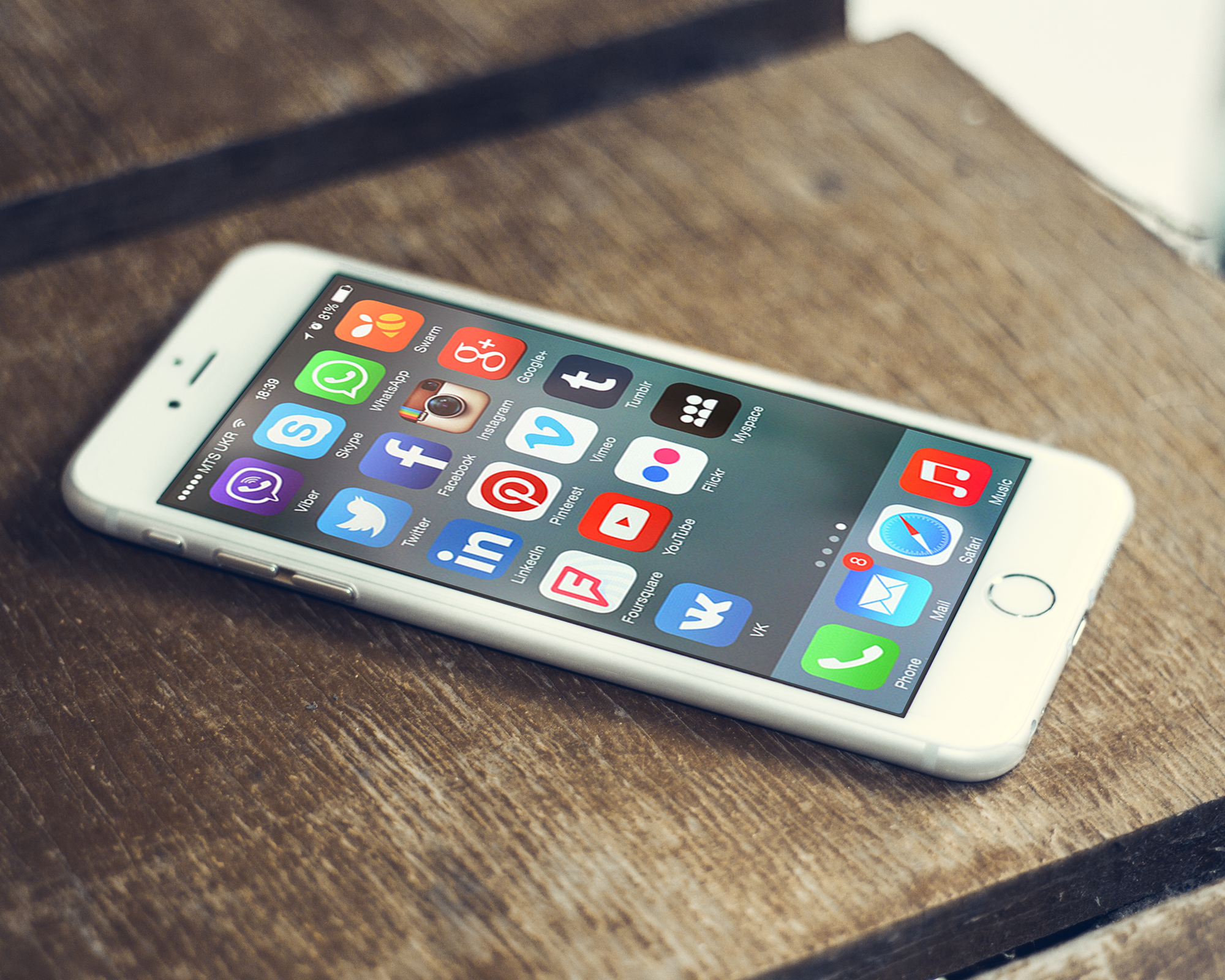 Hand hält ein Smartphone mit geöffneter Kommentarfunktion einer Social-Media-App im Hintergrund unscharf